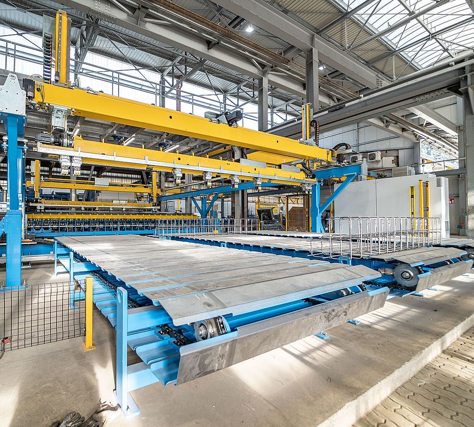 Linea produzione automatizzata con trasportatore trasversale e solai elementi prefabbricati impilati nello stabilimento calcestruzzo
